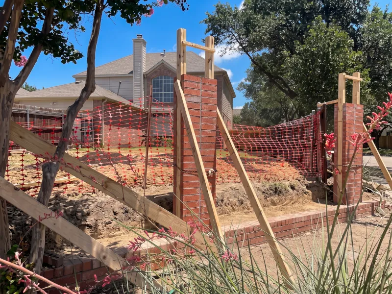 Brick gate columns under construction with wooden formwork and rebar reinforcement